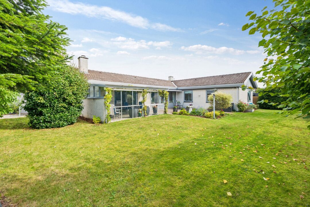 Personer ved bord med laptop og dokumenter