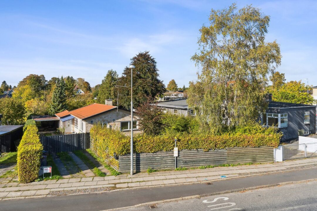 Personer ved bord med laptop og dokumenter